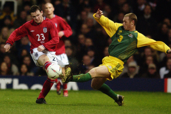Craig Moore gets a tackle in on England debutant Wayne Rooney.