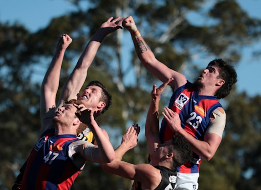Ryan Pendlebury (right) flies to spoil a pack mark for Port Melbourne in a 2019 game.