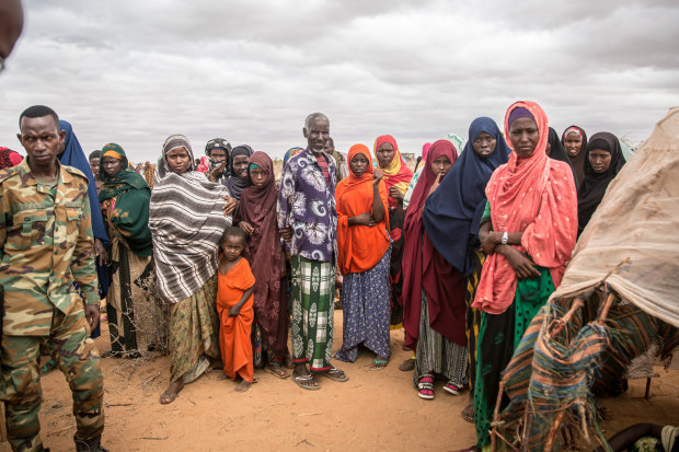 People displaced due to the drought stand around in a camp on the outskirts of Dollow, Jubaland, in Somalia hoping for aid and assistance.