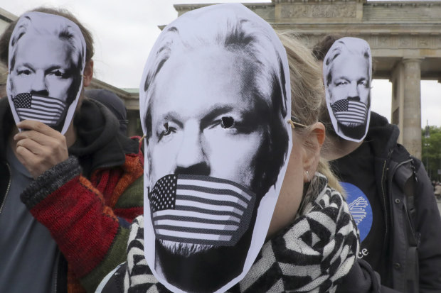 People in Berlin wear masks to protest against Assange’s possible extradition to the US.