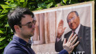 A man poses next to a poster of Silvio Berlusconi outside the former prime minister’s residence in Arcore, near Milan. 
