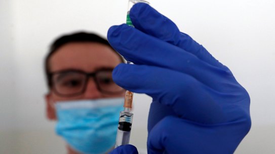 A medical worker prepares to administer a dose of the AstraZeneca vaccine.