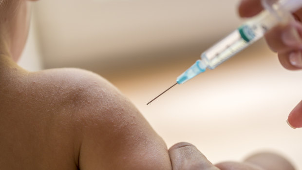 A dctor injecting a young child with a vaccination