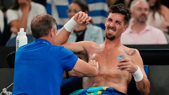 Thanasi Kokkinakis receives treatment during his second round match against Jack Draper.
