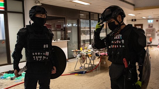 Anti-government protesters with their faces covered stand at Hong Kong Polytechnic University.