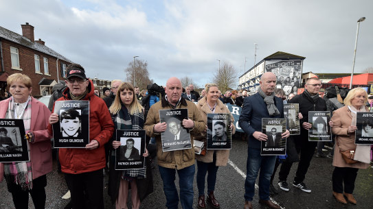 Paul Doherty (centre, holding a picture of Bernard McGuigan, with his niece, Caitlin, to his right) on a protest march for justice for Bloody Sunday victims.