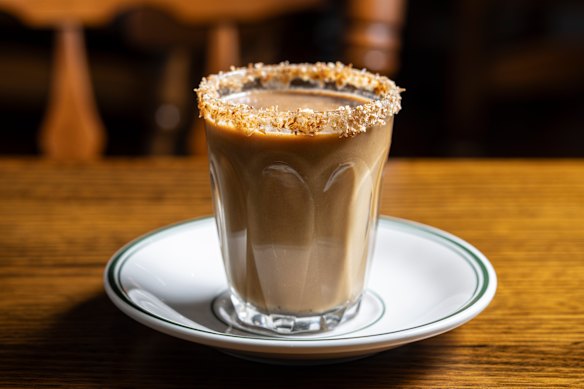 Kopi santan Blora, coffee brewed with coconut milk, rimmed with toasted coconut.