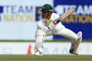 Alex Carey crouches to sweep during the first Test in Galle.