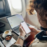 Girl on flight with iphone and laptop
