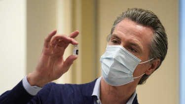 Ο κυβερνήτης της Καλιφόρνιας Gavin Newsom κρατά ένα φιαλίδιο του εμβολίου Pfizer-BioNTech COVID-19.