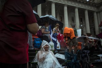 Heavy rain didn’t deter some protesters outside State Parliament