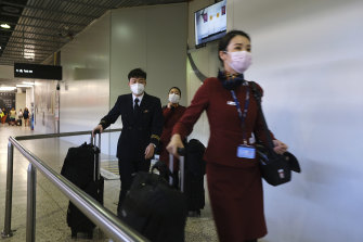 The flight crew wears masks in the arrivals hall at Melbourne Airport.