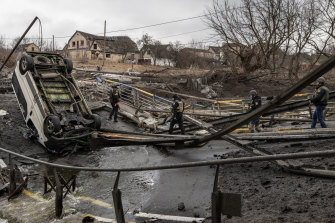 Personalul militar ucrainean traversează un pod distrus lângă linia frontului, pe fondul luptelor din Bucha și Irbin, Ucraina. 