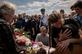 The family of Roman Tkachenko grieves as he is laid to rest at a cemetery in Kyiv, Ukraine, Saturday, June 4.