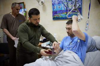 Ukrainian President Volodymyr Zelensky, centre, hands out a state medal to a wounded soldier during his visit to a hospital in Kyiv, Ukraine.