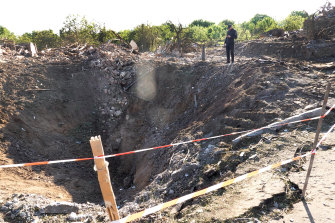 A police officer looks over a crater left by a missile strike in Druzhkivka, Ukraine. 