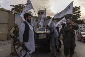 Taliban wave their flags in triumph outside the US embassy in Kabul in August.