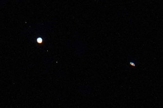 Jupiter, and three of its moons (left) and Saturn (right) are seen above Chicago on December 22, 2020. The two planets were then in their closest observable alignment since 1226.