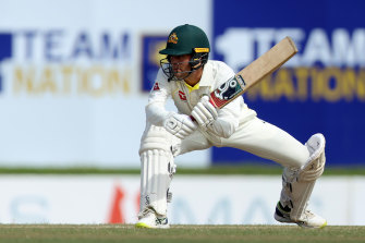 Alex Carey crouches to sweep during the first Test in Galle.