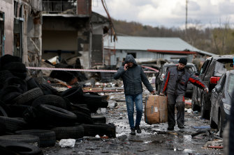 在被俄羅斯導彈擊中後，工人們從他們在利沃夫工作的地方的遺跡中搶救他們所能做的。