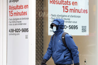 A man walks by a COVID-19 rapid testing lab in Montreal, Canada. Many governments are also looking to shorten the time positive cases need to isolate.