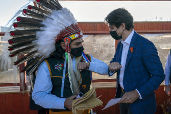 The Canadian government has been fighting the push for compensation through the courts since 2007. Prime Minister Justin Trudeau is seen here greeting indigenous Chief Michael LeBourdais of the Whispering Pines Indian Board in October 2021. 