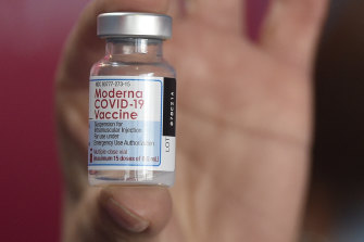 A health worker shows a vial of the Moderna vaccine for COVID-19.