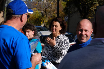 Josh Frydenberg and independent Kooyong candidate Monique Ryan hand out how-to-vote cards to  people attending the Hawthorn pre-polling booth.