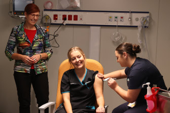 ACT Health Minister Rachel Stephen-Smith watches on as a COVID testing nurse received the first COVID-19 vaccination in the Garran surge centre in February.
