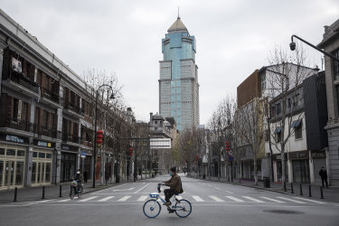 A man by bicycles past an empty street on February 8, 2020 in Wuhan, Hubei province, China. 