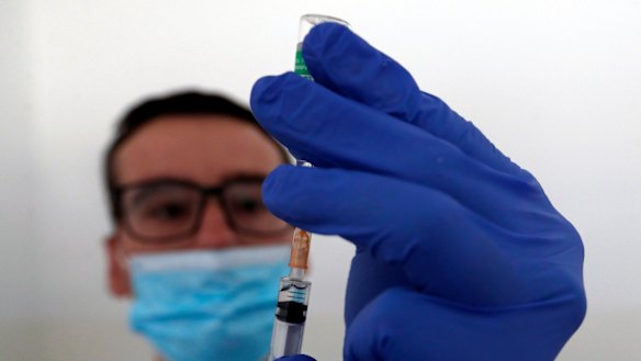 A medical worker prepares to administer a dose of the AstraZeneca vaccine.