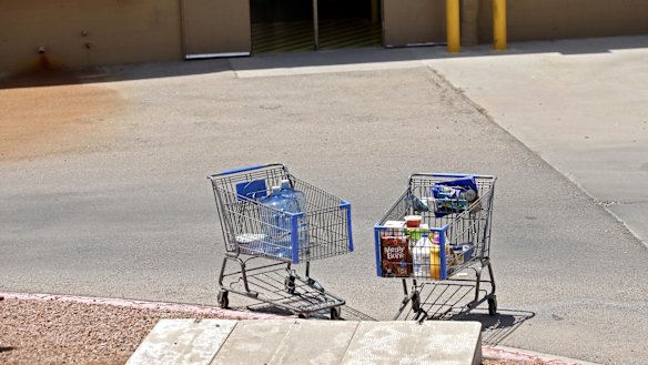 Shopping carts sit next to a curb after a shooting at a Walmart in El Paso, Texas.