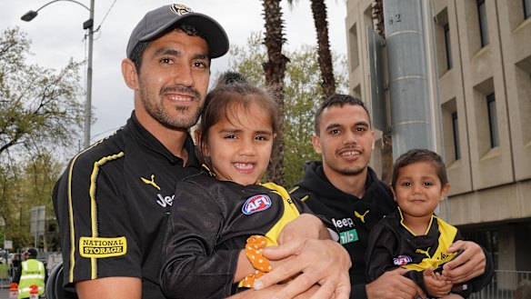 Marlion Pickett holds his daughter Shaniquae as Sydney Stack holds Pickett's son Levi.