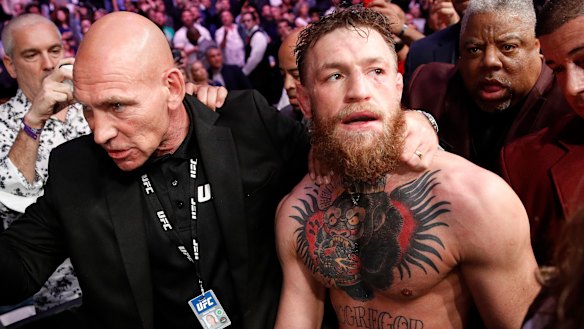 The Irishman is led away by security after the post-fight drama.