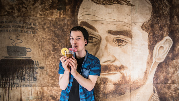 Danny Wilson, holding signature coffee cocktail 'La Leona Soda', poses in front of a portrait of Ona boss and former world barista champion Sasa Sestic.