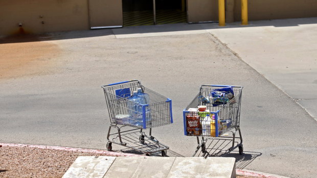 Shopping carts sit next to a curb after a shooting at a Walmart in El Paso, Texas.