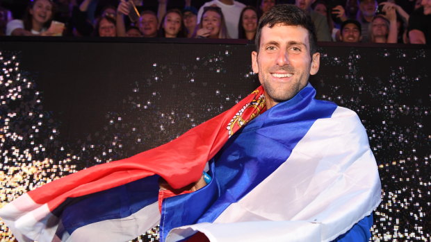Proud moment: Djokovic swathed in the Serbian flag.