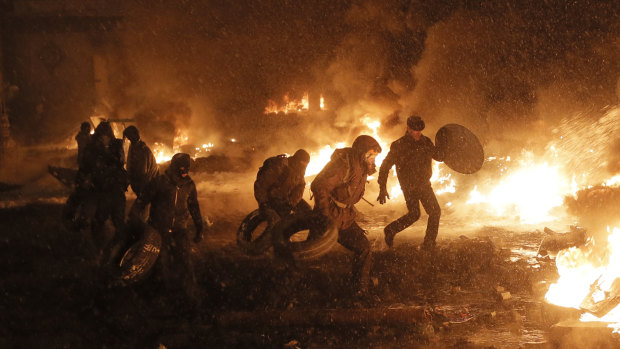 Protesters throw tyres in a fire as they clash with police in central Kiev in January 2014, during the euromaidan uprising that resulted in Yanukovych fleeing to Russia.