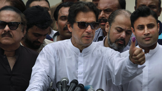 Imran Khan shows his marked thumb after casting his vote.