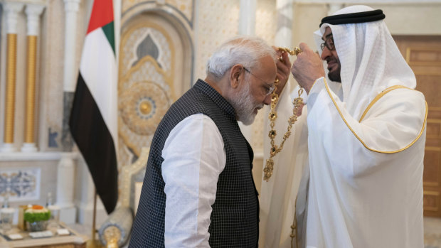 Indian Prime Minister Narendra Modi, left, receives a medal during his induction to the Order of Zayed from Sheikh Mohammed bin Zayed Al Nahyan, right, in Abu Dhabi, UAE.