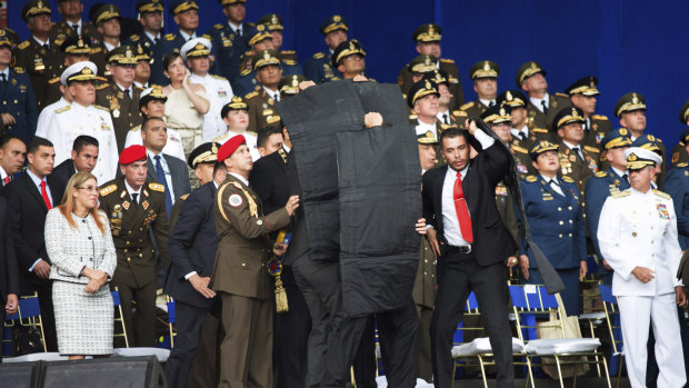 Security personnel surround Venezuela's President Nicolas Maduro during an incident as he was giving a speech in Caracas, Venezuela, on Saturday.