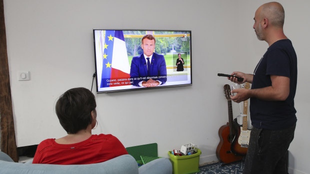 A couple watches Macron's televised address to the nation.