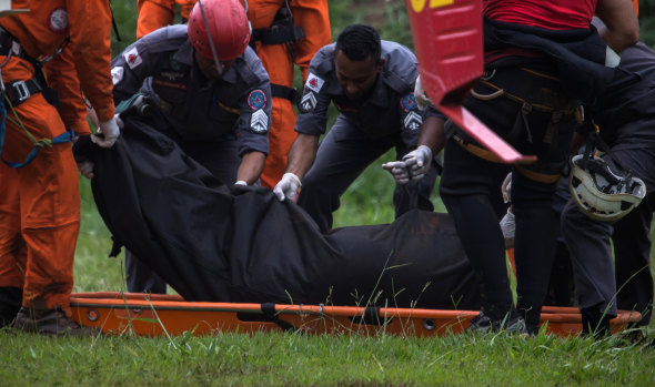 Rescue workers recover the body of a victim after the Vale SA dam burst.