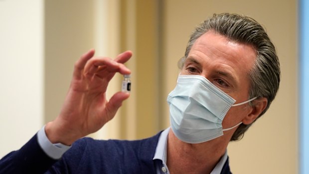 California Governor Gavin Newsom holds up a vial of the Pfizer-BioNTech COVID-19 vaccine.