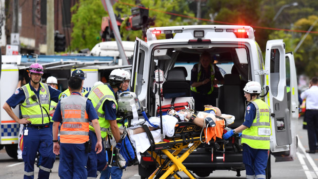 A pedestrian is taken away by paramedics at the scene of the truck crash at Green Square.