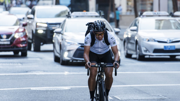 A cyclist rides up King Street, Sydney CBD. 