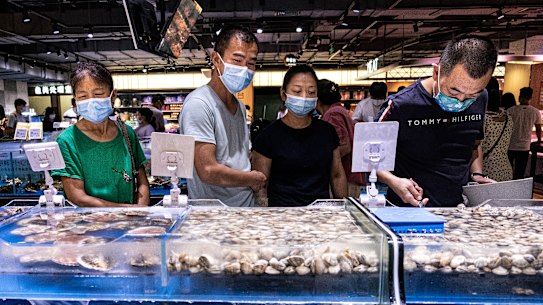 Masked market-goers in Wuhan. Authorities are trying to head off an outbreak of the scale seen in the central China city early last year. 
