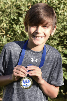 Kade Lovell with his winner's medal for 10km run.