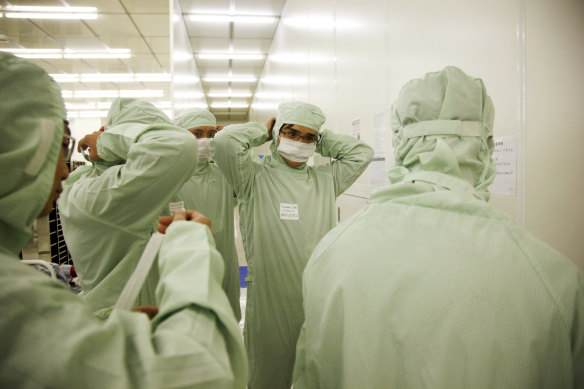 Employees put on clean suits at Semiconductor Manufacturing International Corp (SMIC), in Shanghai, China, which has been targeted by US authorities.