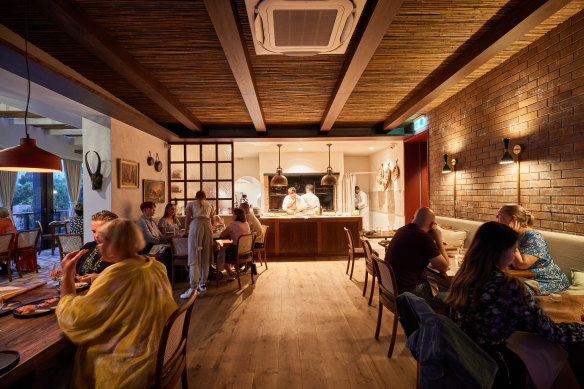 Pilloni’s homely dining room is illuminated by the glow of the hearth.